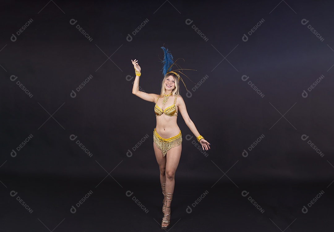 Linda passista loira fantasiada para o carnaval sobre um fundo isolado preto.