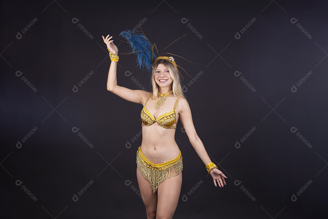 Linda passista loira fantasiada para o carnaval sobre um fundo isolado preto.