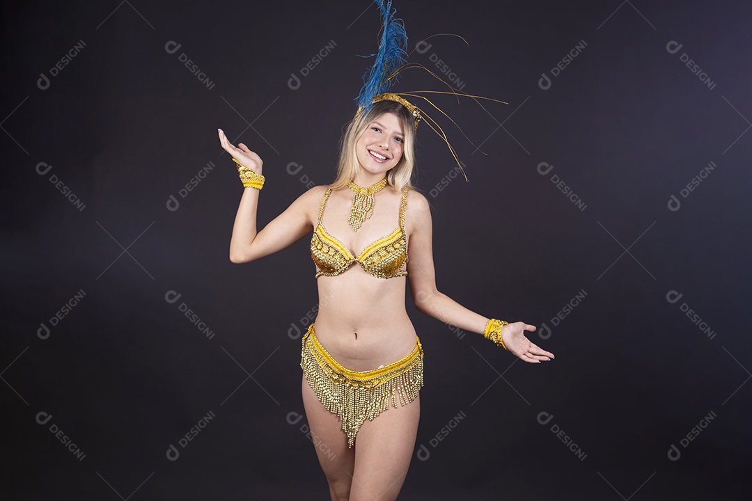 Linda passista loira fantasiada para o carnaval sobre um fundo isolado preto.