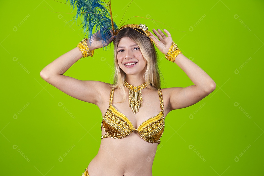 Linda passista loira fantasiada para o carnaval sobre um fundo isolado verde.