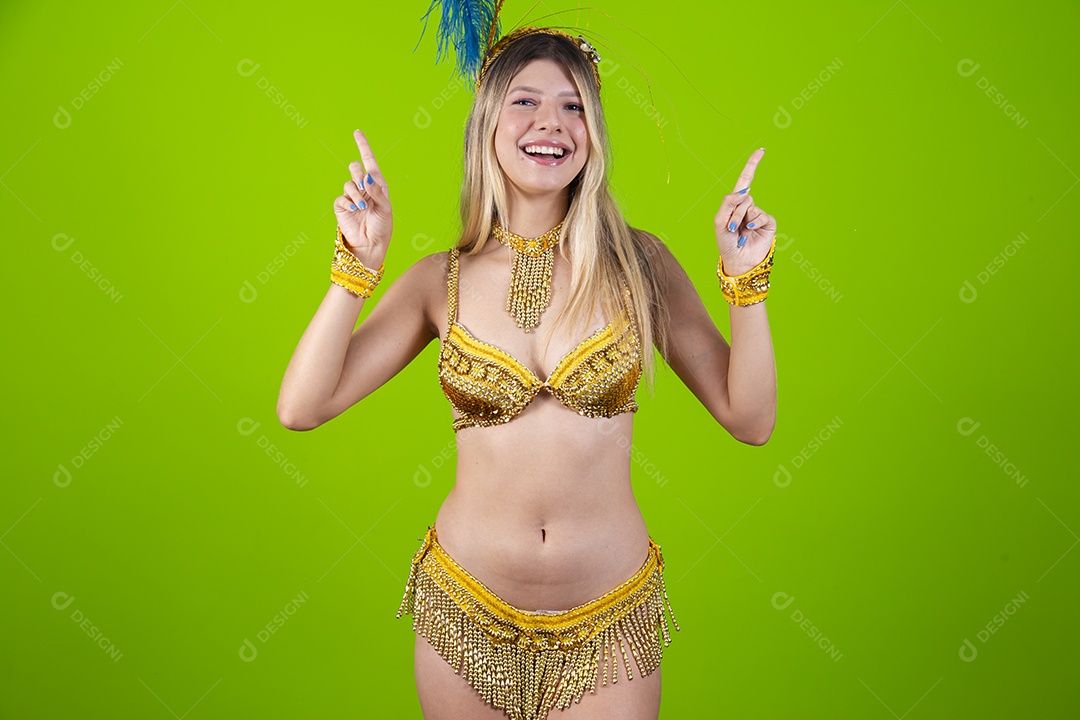 Linda passista loira fantasiada para o carnaval sobre um fundo isolado verde.
