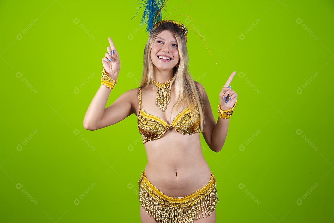 Linda passista loira fantasiada para o carnaval sobre um fundo isolado verde.