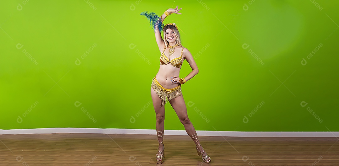 Linda passista loira fantasiada para o carnaval sobre um fundo isolado verde.