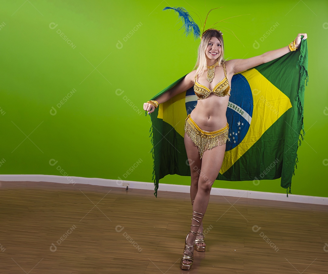 Linda passista loira fantasiada para o carnaval segurando bandeira do Brasil.