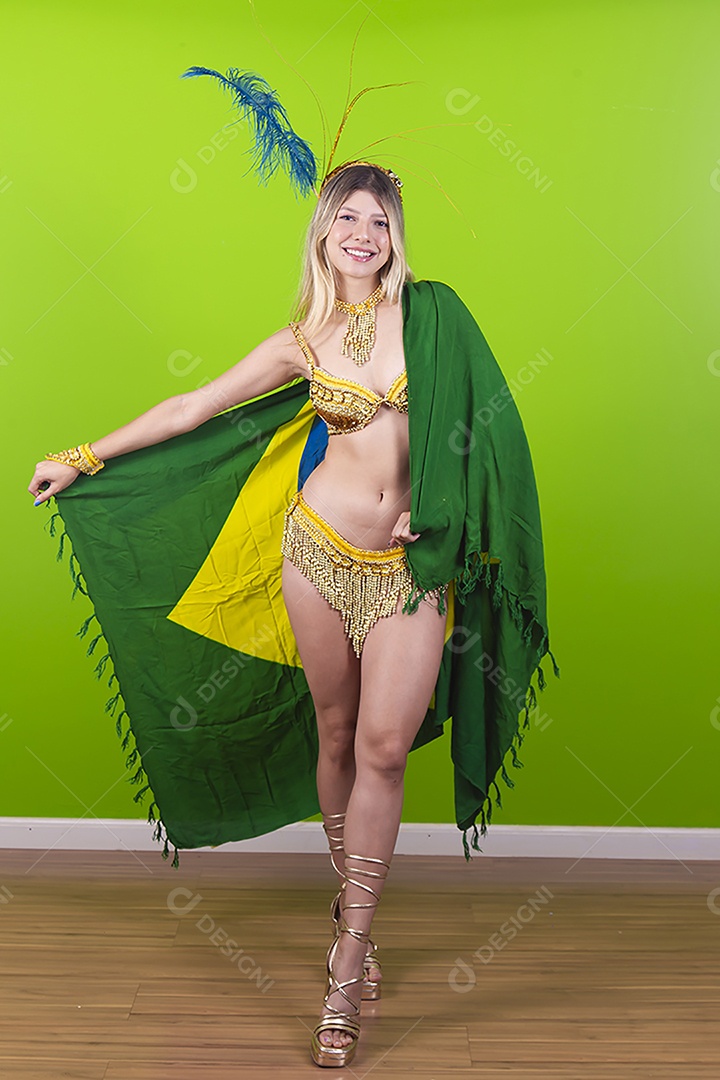 Linda passista loira fantasiada para o carnaval segurando bandeira do Brasil.