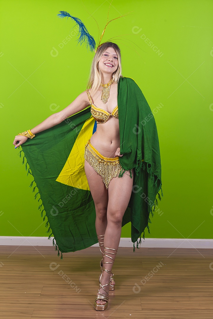 Linda passista loira fantasiada para o carnaval segurando bandeira do Brasil.
