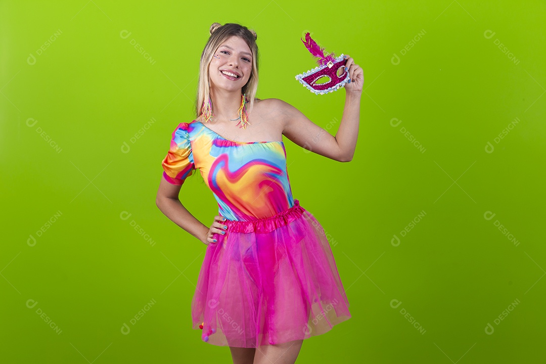 Linda mulher loira segurando máscara carnavalescas sobre um fundo isolado verde.
