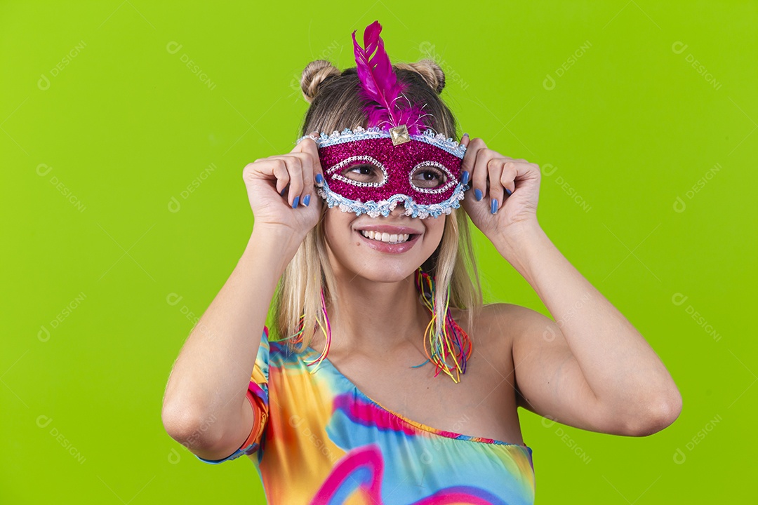 Linda mulher loira usando máscara carnavalesca sobre um fundo isolado verde.