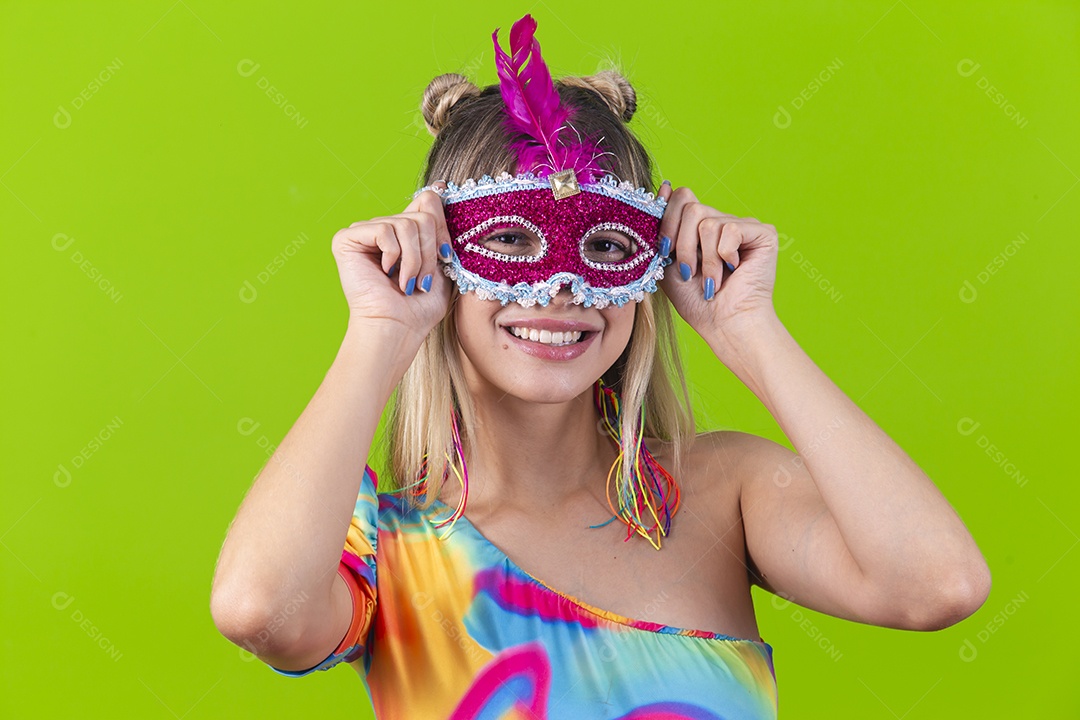Linda mulher loira usando máscara carnavalesca sobre um fundo isolado verde.