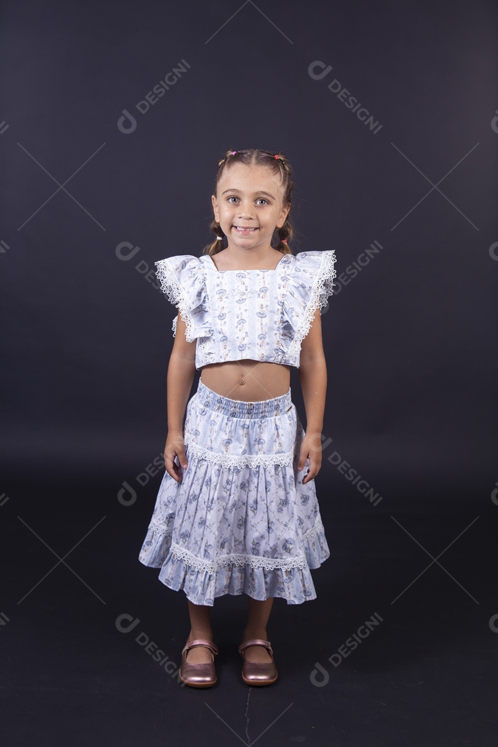 Linda menina vestida de conjunto florido sobre um fundo isolado preto