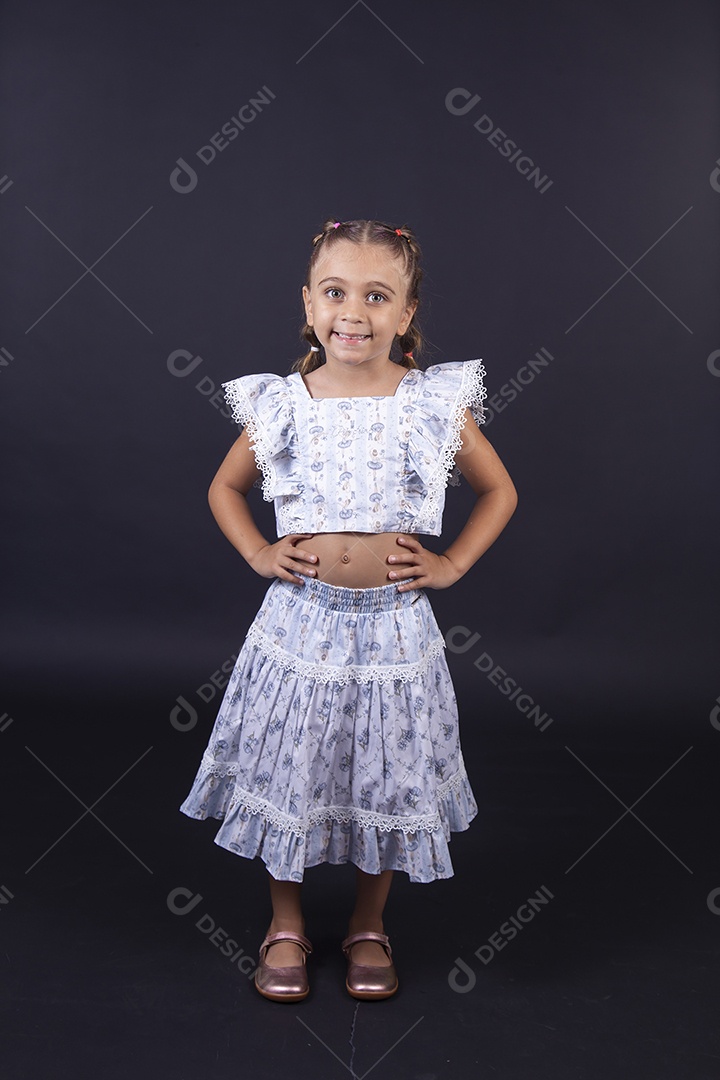 Linda menina vestida de conjunto florido sobre um fundo isolado preto