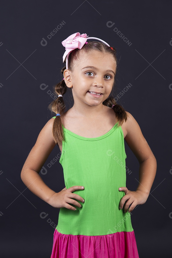 Linda menina usando vestido  sobre um fundo isolado preto.