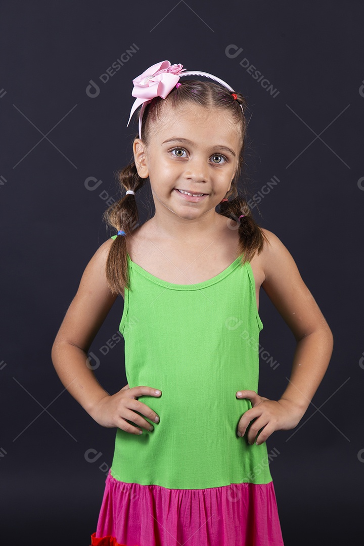 Linda menina usando vestido  sobre um fundo isolado preto.
