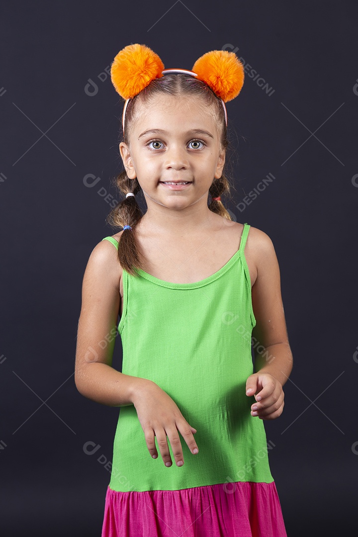 Linda menina usando vestido colorido sobre um fundo isolado preto.