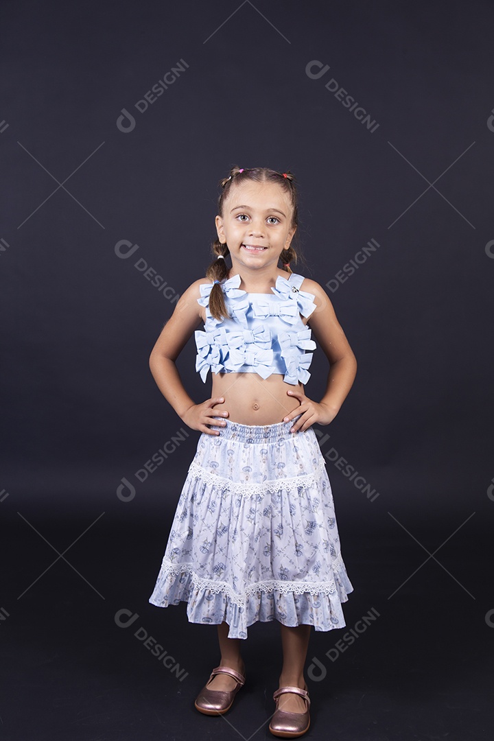 Linda menina vestida de conjunto florido sobre um fundo isolado preto