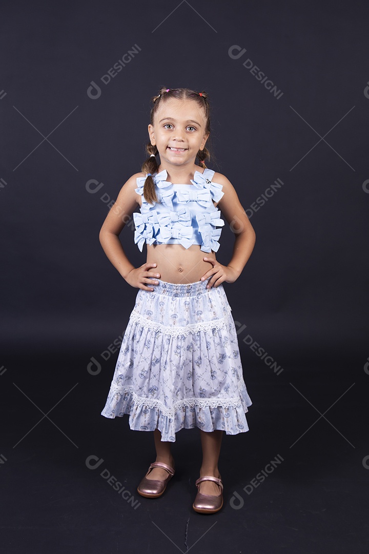 Linda menina vestida de conjunto florido sobre um fundo isolado preto