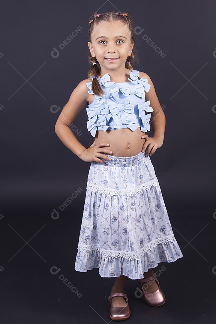 Linda menina vestida de conjunto florido sobre um fundo isolado preto