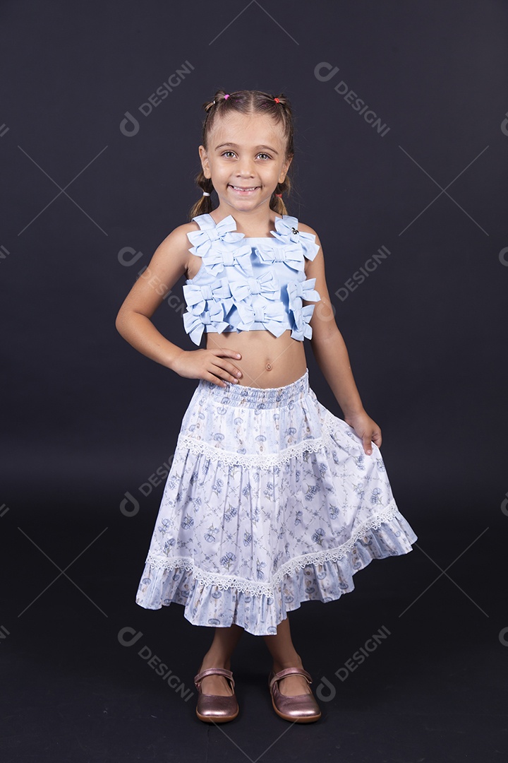 Linda menina vestida de conjunto florido sobre um fundo isolado preto