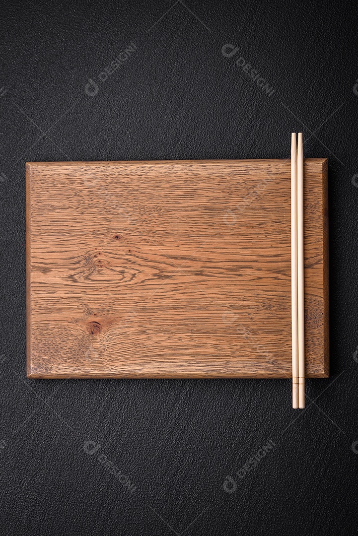 Pauzinhos de madeira leves sobre um fundo em branco como pano de fundo para um prato asiático. Copie o espaço com utensílios de comida