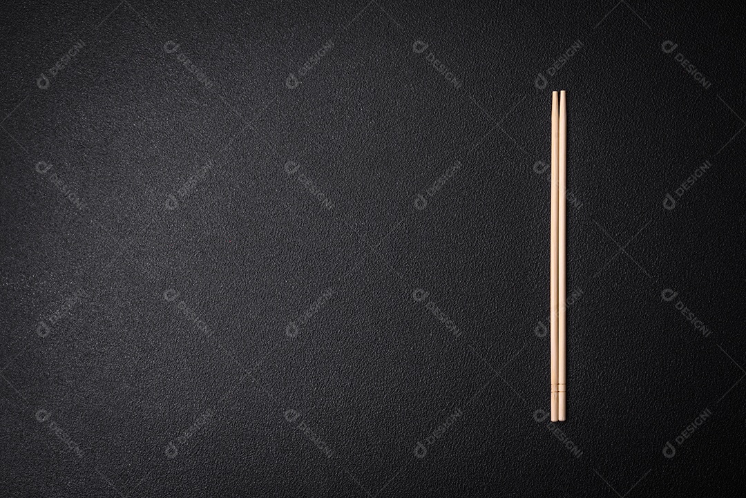 Pauzinhos de madeira leves sobre um fundo em branco como pano de fundo para um prato asiático. Copie o espaço com utensílios de comida