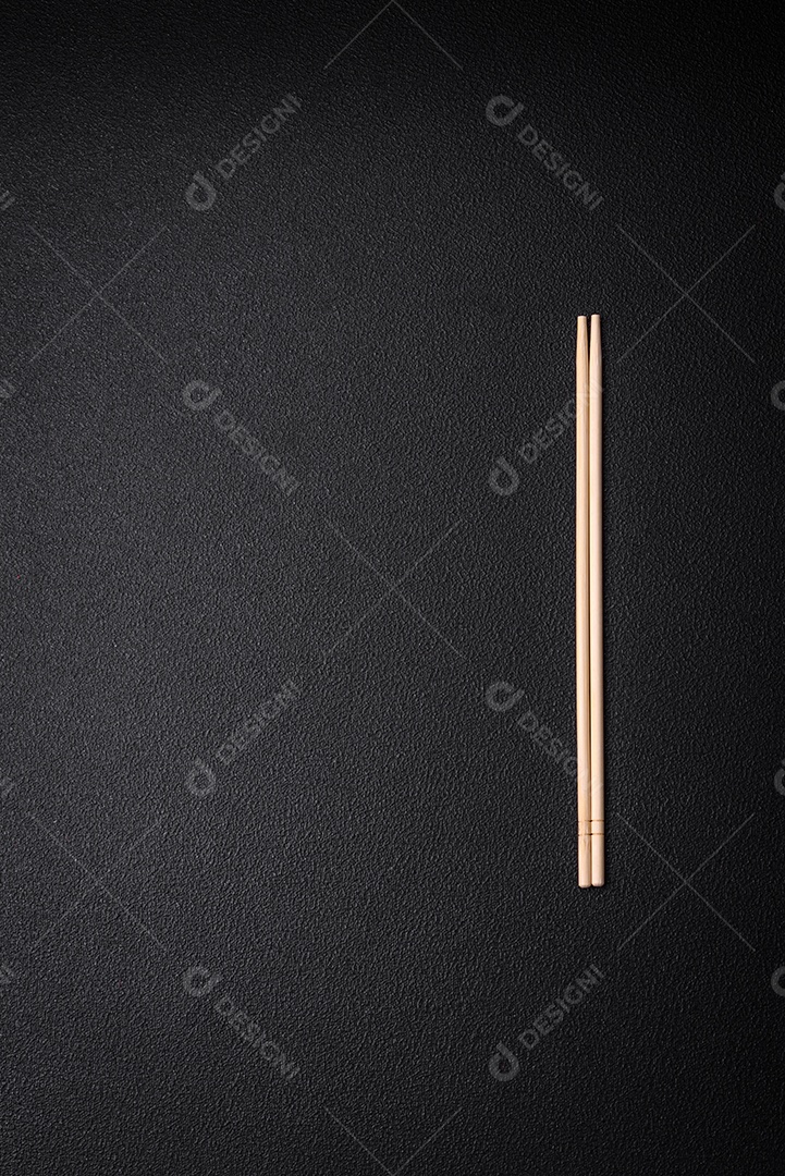 Pauzinhos de madeira leves sobre um fundo em branco como pano de fundo para um prato asiático. Copie o espaço com utensílios de comida