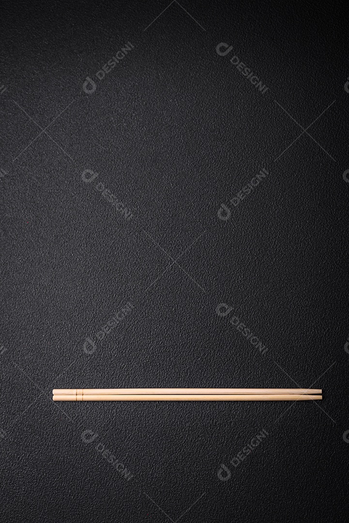 Pauzinhos de madeira leves sobre um fundo em branco como pano de fundo para um prato asiático. Copie o espaço com utensílios de comida