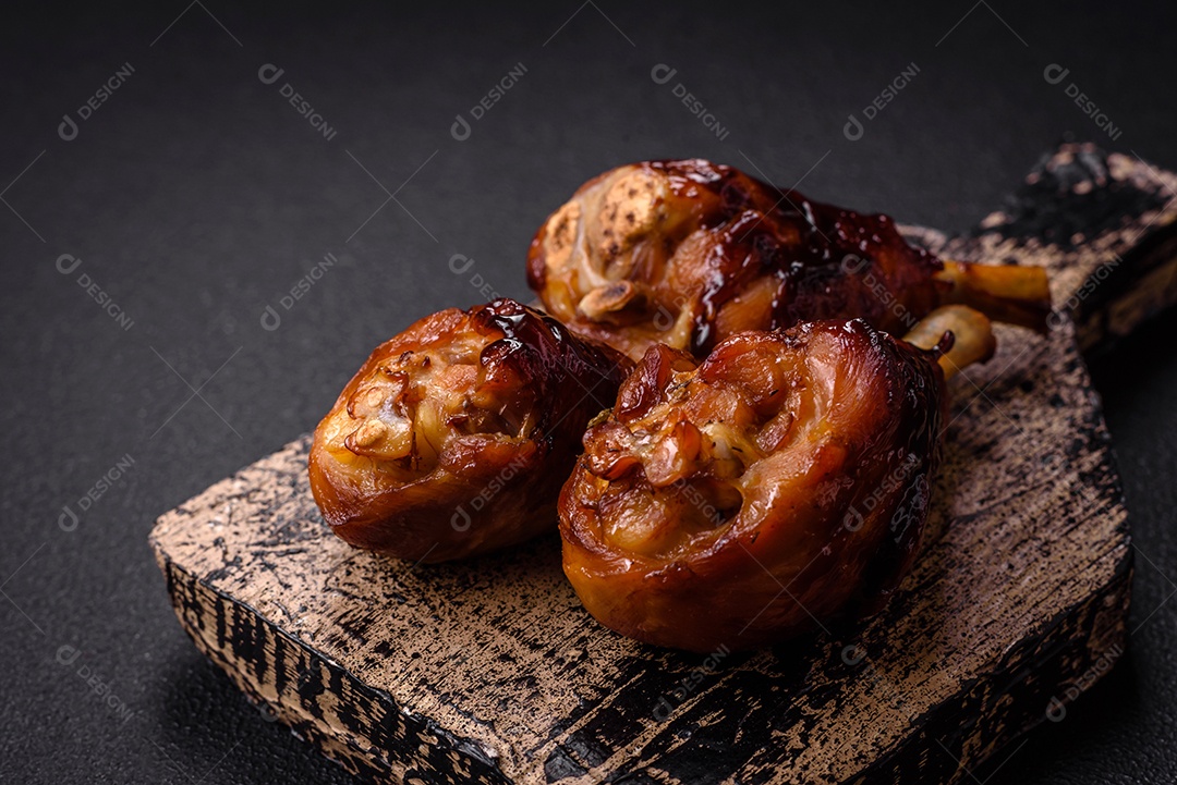 Deliciosos champignon inteiros e suculentos assados ​​na grelha com sal e especiarias em uma placa de cerâmica sobre um fundo escuro de concret