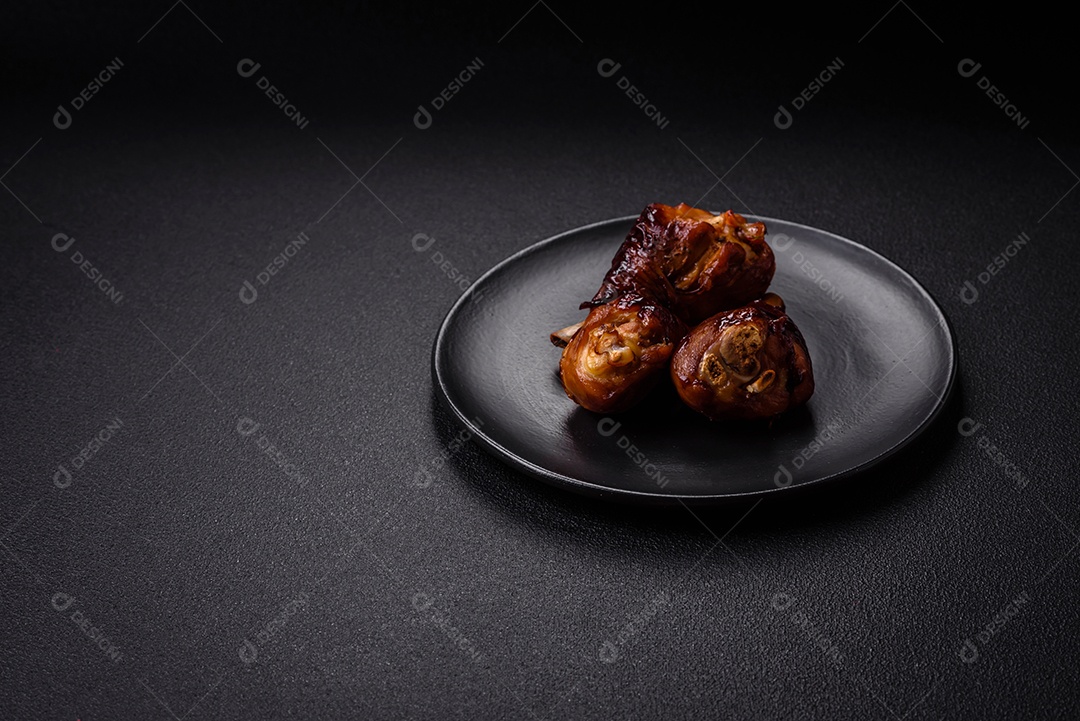 Deliciosos champignon inteiros e suculentos assados ​​na grelha com sal e especiarias em uma placa de cerâmica sobre um fundo escuro de concreto