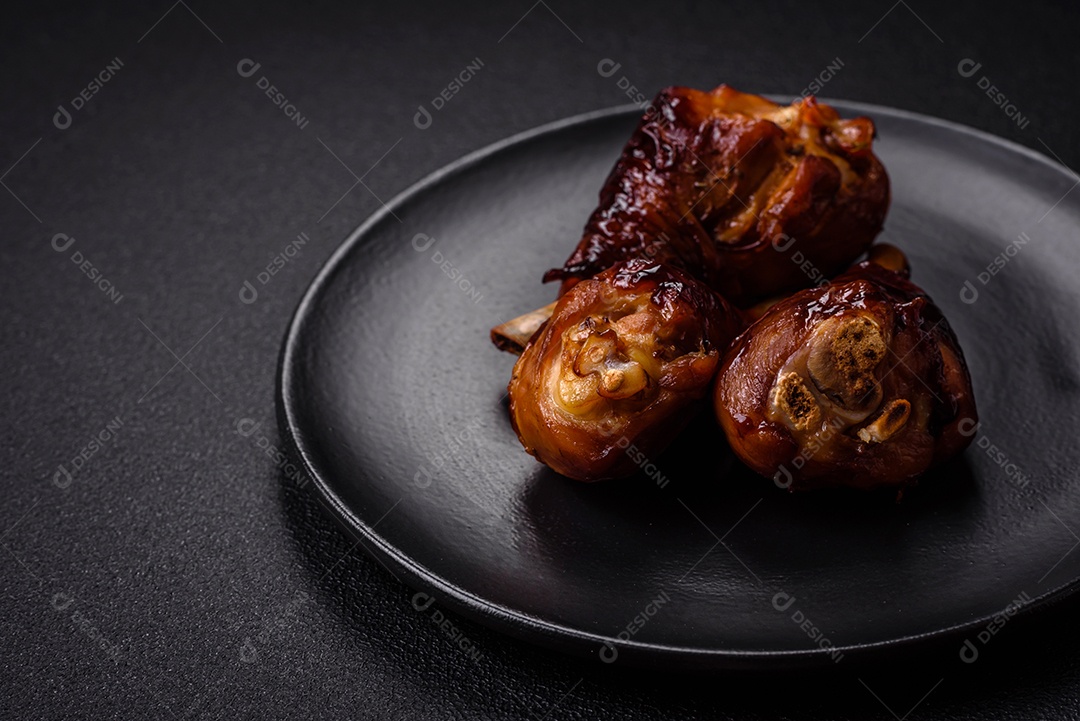 Deliciosos champignon inteiros e suculentos assados ​​na grelha com sal e especiarias em uma placa de cerâmica sobre um fundo escuro de concreto