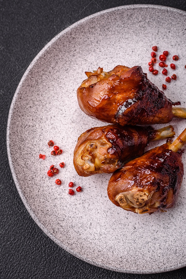 Deliciosos champignon inteiros e suculentos assados ​​na grelha com sal e especiarias em uma placa de cerâmica sobre um fundo escuro de concreto