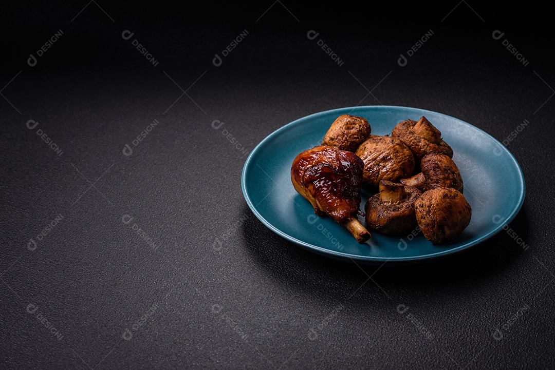 Deliciosos champignon inteiros e suculentos assados ​​na grelha com sal e especiarias em uma placa de cerâmica sobre um fundo escuro de concreto
