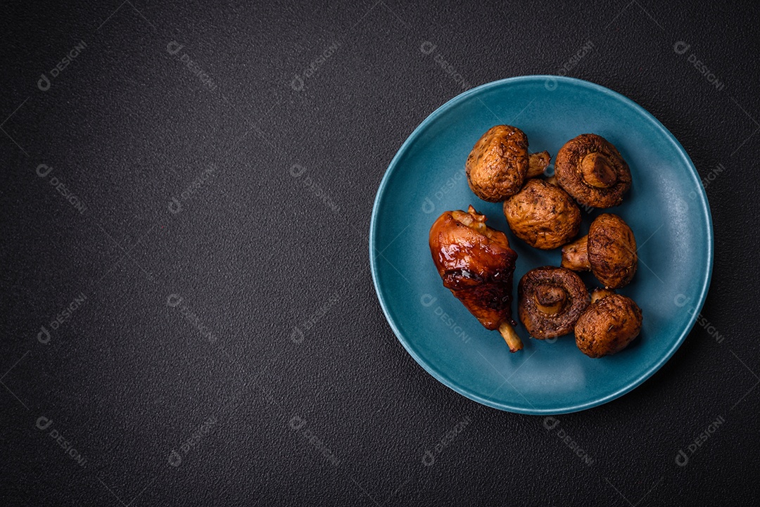Deliciosos champignon inteiros e suculentos assados ​​na grelha com sal e especiarias em uma placa de cerâmica sobre um fundo escuro de concreto