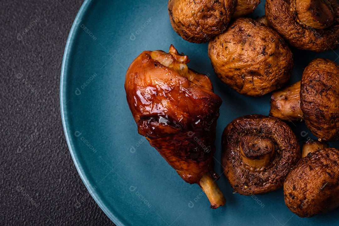 Deliciosos champignon inteiros e suculentos assados ​​na grelha com sal e especiarias em uma placa de cerâmica sobre um fundo escuro de concreto