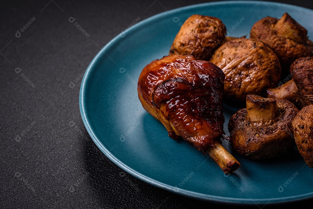 Deliciosos champignon inteiros e suculentos assados ​​na grelha com sal e especiarias em uma placa de cerâmica sobre um fundo escuro de concreto