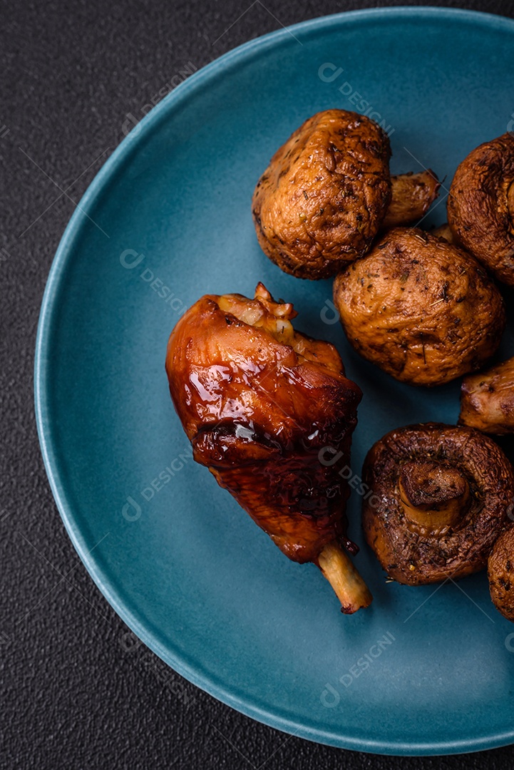 Deliciosos champignon inteiros e suculentos assados ​​na grelha com sal e especiarias em uma placa de cerâmica sobre um fundo escuro de concreto