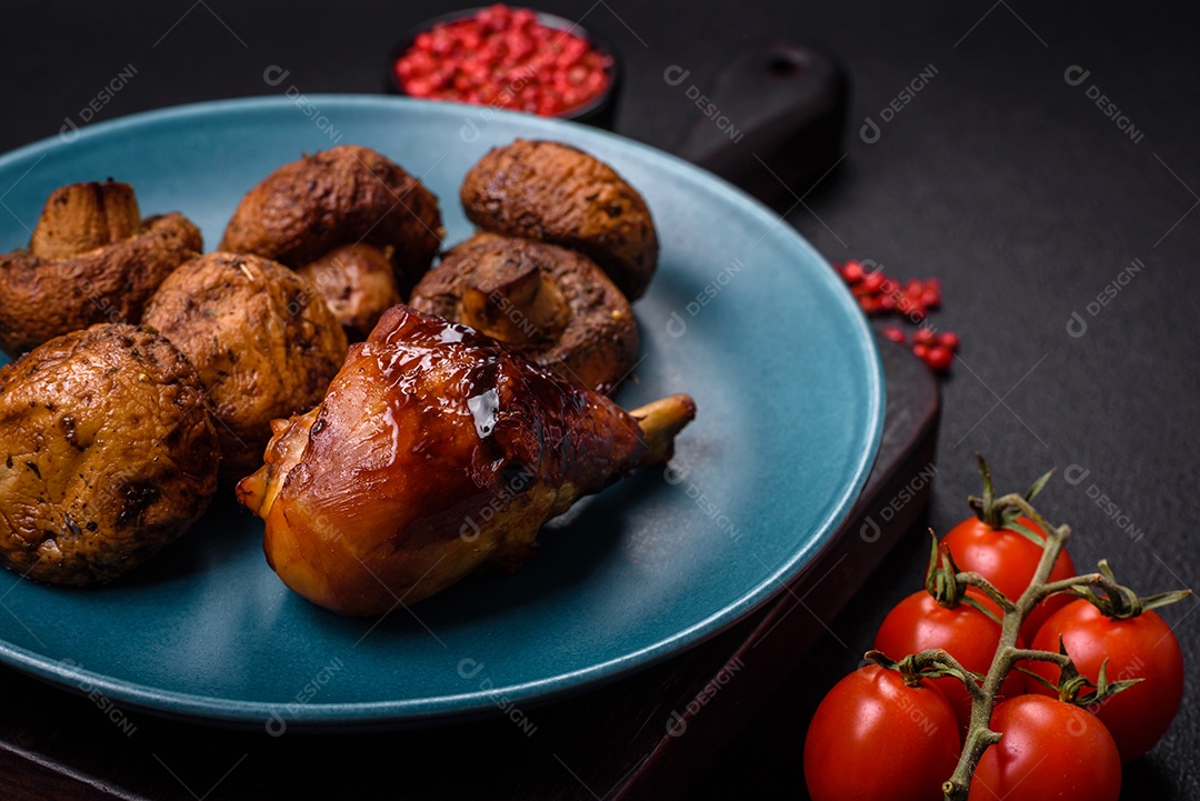 Deliciosos champignon inteiros e suculentos assados ​​na grelha com sal e especiarias em uma placa de cerâmica sobre um fundo escuro de concreto