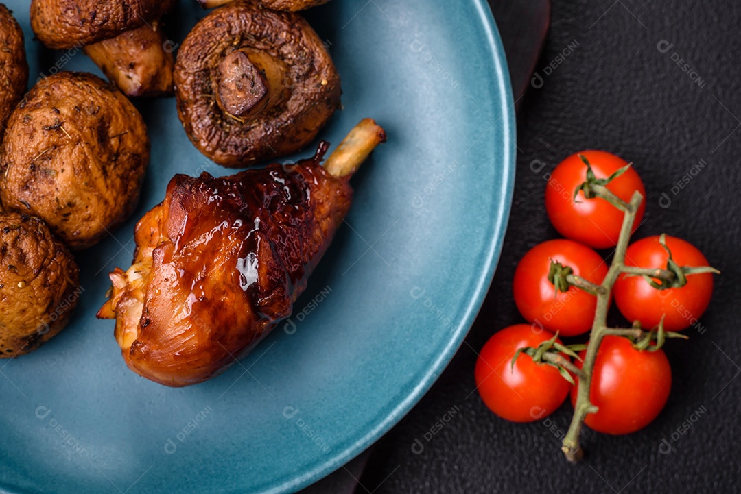 Deliciosos champignon inteiros e suculentos assados ​​na grelha com sal e especiarias em uma placa de cerâmica sobre um fundo escuro de concreto