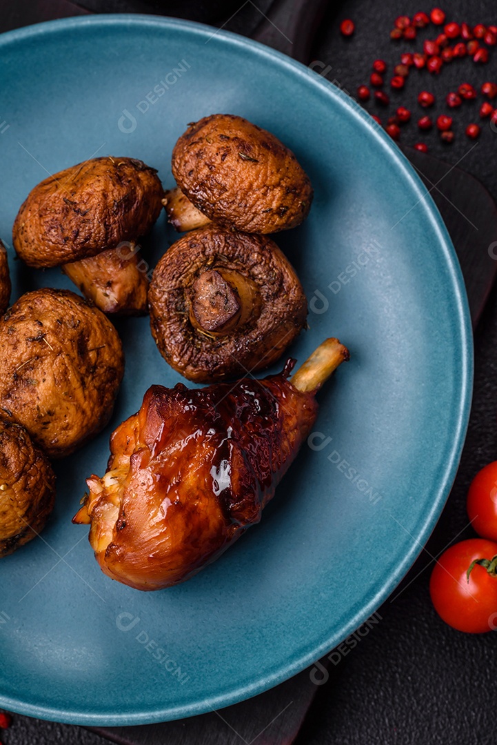 Deliciosos champignon inteiros e suculentos assados ​​na grelha com sal e especiarias em uma placa de cerâmica sobre um fundo escuro de concreto