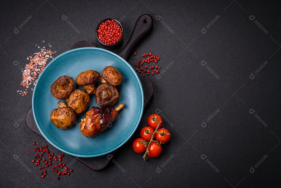 Deliciosos champignon inteiros e suculentos assados ​​na grelha com sal e especiarias em uma placa de cerâmica sobre um fundo escuro de concreto