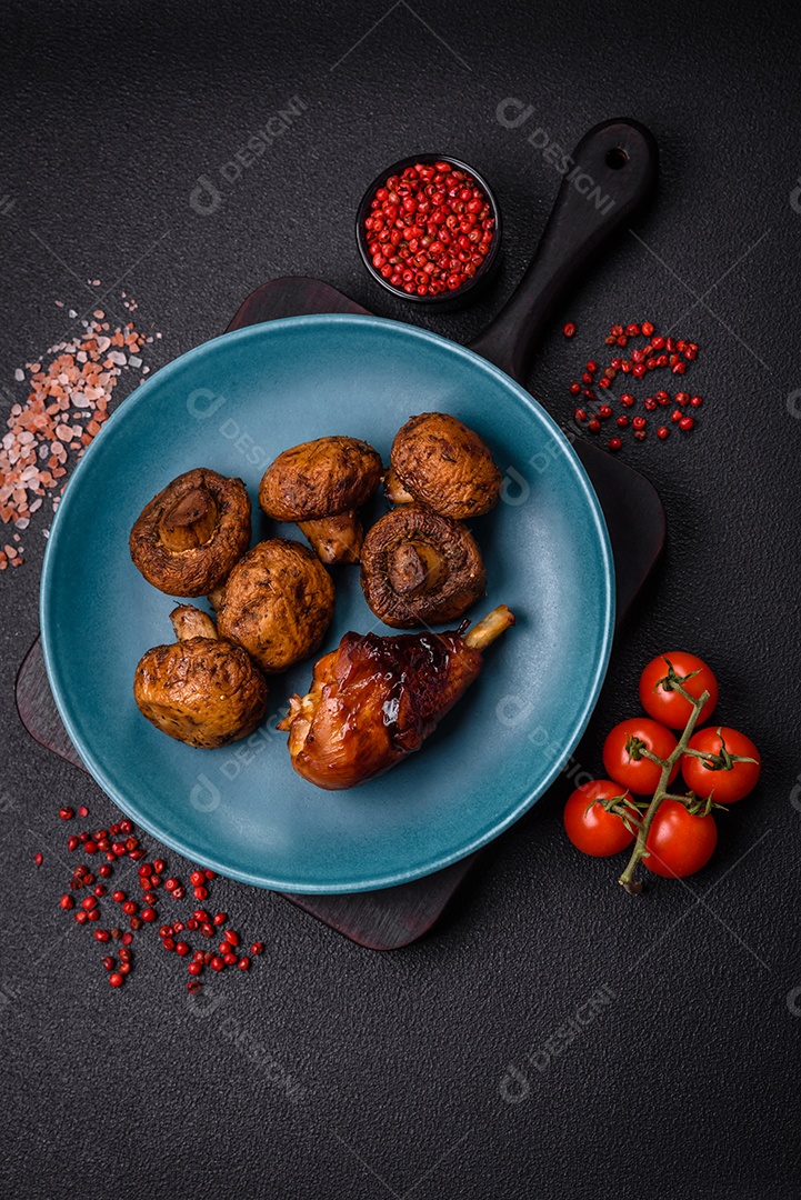 Deliciosos champignon inteiros e suculentos assados ​​na grelha com sal e especiarias em uma placa de cerâmica sobre um fundo escuro de concreto