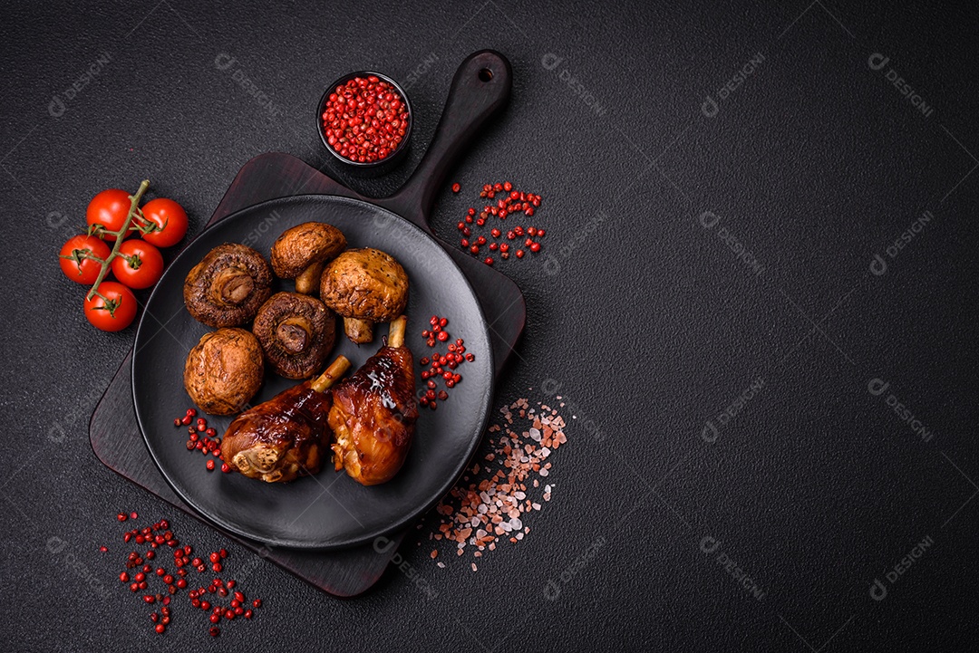 Deliciosos champignon inteiros e suculentos assados ​​na grelha com sal e especiarias em uma placa de cerâmica sobre um fundo escuro de concreto