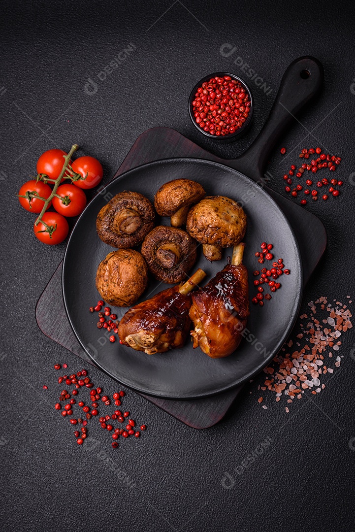 Deliciosos champignon inteiros e suculentos assados ​​na grelha com sal e especiarias em uma placa de cerâmica sobre um fundo escuro de concreto