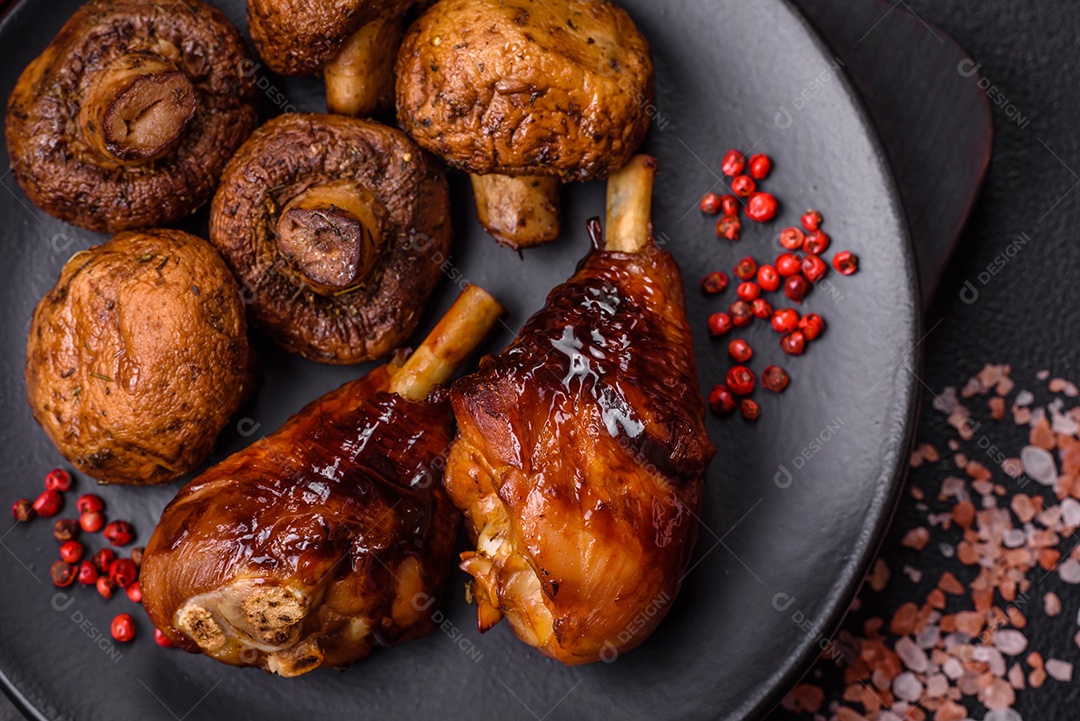 Deliciosos champignon inteiros e suculentos assados ​​na grelha com sal e especiarias em uma placa de cerâmica sobre um fundo escuro de concreto