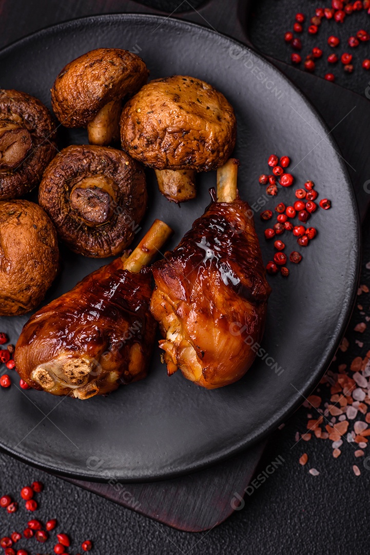 Deliciosos champignon inteiros e suculentos assados ​​na grelha com sal e especiarias em uma placa de cerâmica sobre um fundo escuro de concreto