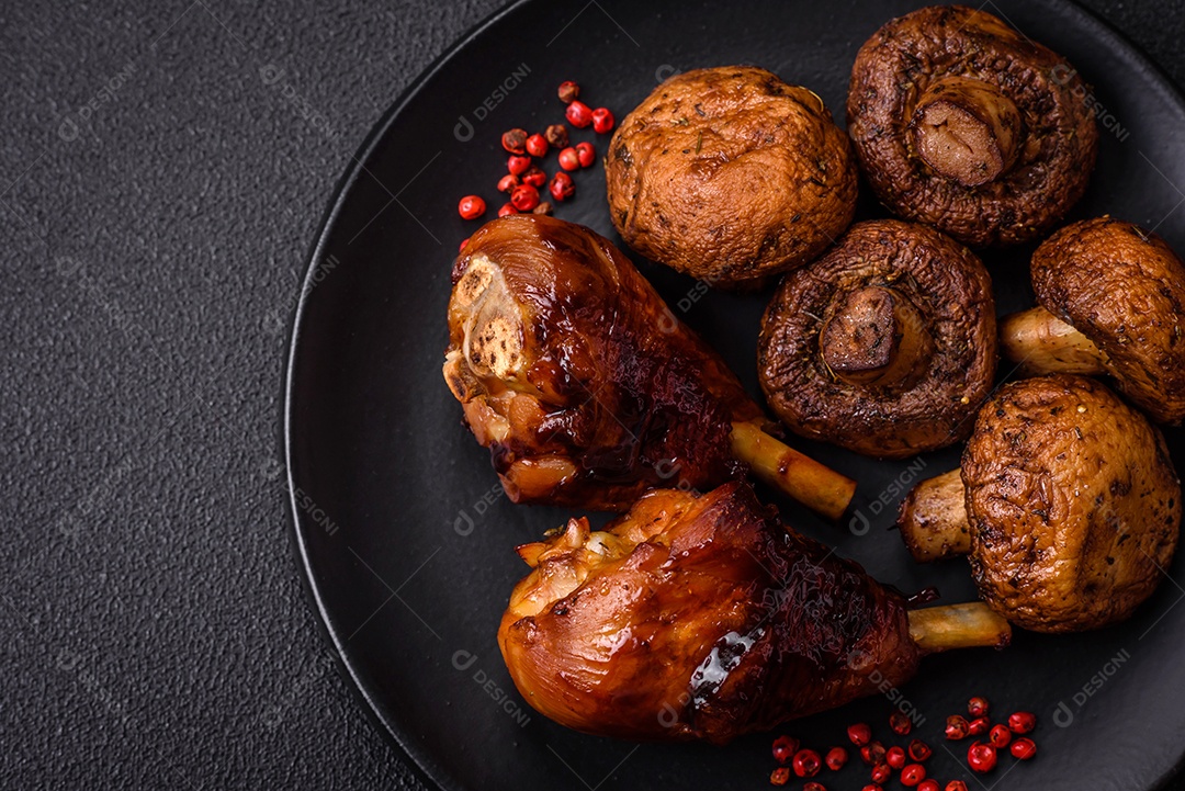 Deliciosos champignon inteiros e suculentos assados ​​na grelha com sal e especiarias em uma placa de cerâmica sobre um fundo escuro de concreto