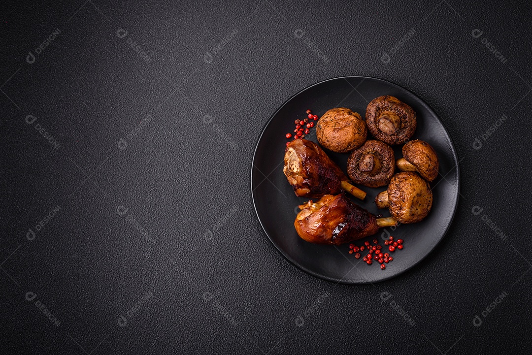 Deliciosos champignon inteiros e suculentos assados ​​na grelha com sal e especiarias em uma placa de cerâmica sobre um fundo escuro de concreto