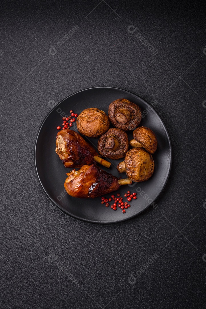 Deliciosos champignon inteiros e suculentos assados ​​na grelha com sal e especiarias em uma placa de cerâmica sobre um fundo escuro de concreto