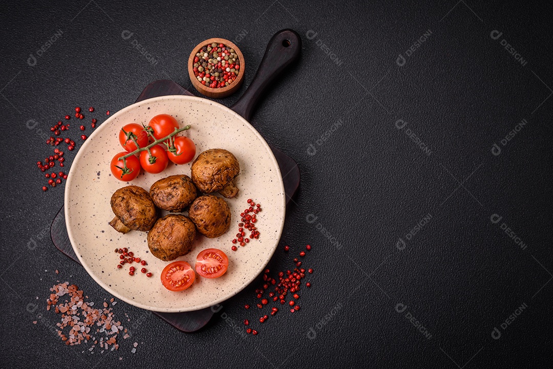 Deliciosos champignon inteiros e suculentos assados ​​na grelha com sal e especiarias em uma placa de cerâmica sobre um fundo escuro de concreto