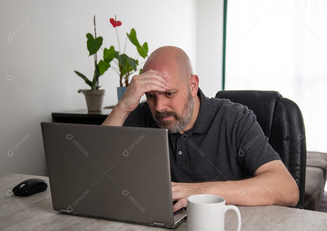 Empresário preocupado usando um laptop trabalhando em casa