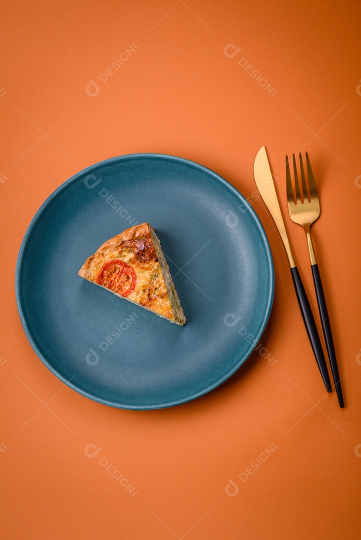Deliciosa quiche com tomate, queijo, frango, especiarias e ervas sobre um fundo escuro de concreto